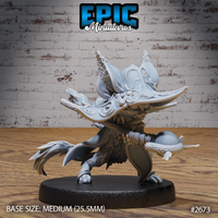 Cat folk druid miniature facing forward, wearing wide-brimmed filigree hat with curled horns, ornate layered robes, holding a decorated staff. Sculpt by Epic Miniatures.