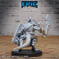 Armoured kobold warrior seen from behind, thick layered back armour and large slab shield visible on the left arm, serrated blade raised in the right hand, thick tail trailing low. Sculpt by Epic Miniatures.