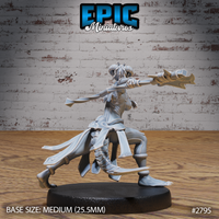 Lizardfolk female warrior gripping a long staff with both hands, weight forward in an aggressive crouch. Braided locs, clawed feet, layered wrapped garments visible from behind. Sculpt by Epic Miniatures.
