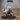 Crocodile Hunchback by Epic Miniatures — heavily scaled bipedal crocodilian crouching forward, jaws lashed with iron rope and spikes, gripping a hooked scythe-blade, raised spur-studded carapace, on a large decorative base.