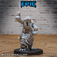 Rear view of the lizardfolk alchemist showing a heavily armoured, scale-textured tail curling outward, a barrel strapped to the back with rope, and the raised arm extended upward gripping a flask. Sculpt by Epic Miniatures.