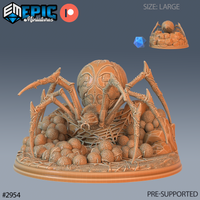 Large resin miniature of a giant dungeon spider crouching over a nest of dozens of round eggs, with intricate web detail beneath her thorax, barbed segmented legs spread wide, and a rocky rubble base — unpainted orange resin render shown alongside a d20 for scale, sculpted by Epic Miniatures