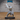 Bald muscular monk in a wide combat stance, both swords raised and crossed at the guard, bare torso with bead necklace, flowing sash and wide trousers. Sculpt by Epic Miniatures.