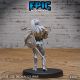 Female elf fighter shown from behind, long ponytail flowing down her back, large round knotwork shield strapped across her shoulders, longsword hanging at her side. Detailed studded leg armour and layered fur collar visible. Sculpt by Epic Miniatures.