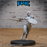Female elf fighter stepping forward with a long sword extended and an engraved round shield raised, wearing studded leather armour with a belted waist and short cape, serpentine sword hilt detail. Sculpt by Epic Miniatures.