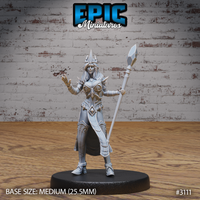 Female wizard facing forward, spiked crown on her head, crystal-tipped staff held at an angle in one hand, other hand raised mid-cast with fingers splayed. Sculpt by Epic Miniatures.