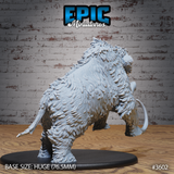 Rear three-quarter view of the same unpainted grey resin woolly mammoth miniature — showing the heavily detailed shaggy fur across the back and haunches, bony ridge spines along the spine, rear legs driving forward mid-charge, on a 76.5mm oval base. Epic Miniatures sculpt #3602.