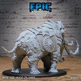Rear three-quarter view of the Armoured Mammoth miniature by Epic Miniatures — unpainted grey resin on a 76.5mm black base, showing deep fur texture across the lower body, stacked back-plate armour, chainmail barding panels, and the bladed tusk weapon visible in the foreground