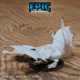 Unpainted grey resin white dragon wyrmling miniature by Epic Miniatures, viewed from the rear — showing the segmented ridged tail, spread leathery wings with visible vein detail, and powerful clawed feet on a medium 25.5mm base