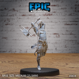 Front view of an unpainted grey resin 3D printed cave elf barbarian miniature by Epic Miniatures — male figure mid-leap with one knee raised, both hands gripping a large spiked war hammer held overhead ready to strike, wearing minimal wrappings, layered loincloth, broad shoulder collar, and bound leg wrappings, with long braided hair swept back, on a 25.5mm medium round black base