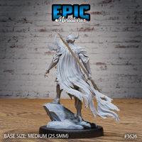 Rear view of the unpainted grey resin Frost Demon Knight miniature showing the full sweep of the tattered cape, detailed fabric texture, horned helm from behind, armour layering across back and shoulders, curved blade visible at side, rocky terrain base, by Epic Miniatures