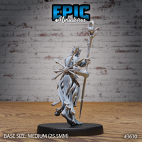 Rear three-quarter view of the unpainted grey resin Old Heretic miniature by Epic Miniatures, showing the flowing tattered robes, the back of the skull-topped staff, bundled spear hafts, and detailed wrap bindings on the forearms, on a medium 25.5mm round black base