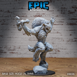 Front view of an unpainted grey resin Yeenoghu Demon Lord miniature on a huge 76.5mm base — shown mid-leap from a shattered rock, jaws snarling wide, one clawed hand raised and a large ornate axe hauled back to strike, with a massive matted mane and ridge-covered torso