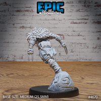 Unpainted grey resin Beast Master miniature by Epic Miniatures, shown from the rear. The back of the figure reveals the flowing wild hair, backpack straps and pouches across the torso, twin blades extended from both clawed hands, and the dramatic forward-leaning pose over the rocky scenic base.
