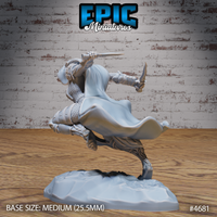 Rear three-quarter view of an unpainted grey resin armoured female werewolf miniature showing the full sweep of her flowing cloak, segmented back armour, and dual-dagger grip, dynamic single-foot pose on a textured rocky base, Epic Miniatures sculpt number 4681, 32mm scale