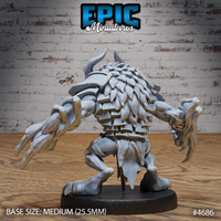 Rear view of the unpainted grey resin Skull Bear miniature showing broad shoulders covered in layered feather-like scales, swept-back horns, and powerful clawed arms spread wide in a threatening stance, on a medium 25.5mm round base