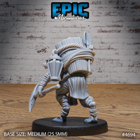 Rear three-quarter view of the unpainted grey resin Gnoll Tribe Miner miniature showing the intricately detailed back pack — tightly bound bundles, rope loops, and a blade handle jutting above the load, with cloth and cord wrappings visible across the torso and legs