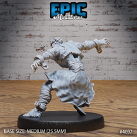 Rear three-quarter view of the same unpainted grey resin savage escapee miniature, showing the flowing tattered coat, shackle cuffs on both wrists, wrapped forearms, bare feet, and the dynamic lunging posture from behind