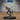 Unpainted grey resin miniature of a male human in ragged torn clothing sprinting forward, one foot raised mid-stride, arms driving forward with wrapped hands, on a 25.5mm round black base — front view
