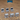 Six unpainted grey resin Lich Crypt Chest scatter terrain pieces by Epic Miniatures — three open-lidded chests with skull, winged, and plain iron designs alongside three closed chests with skull clasps, spike-studded lids, and padlock fittings, photographed on a wooden surface