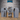 Three unpainted grey resin coffin terrain pieces from Epic Miniatures, shown open and from the front: left coffin open revealing a mummified figure wrapped in bandages, centre coffin chained shut with skeletal hands breaking through the splintered lid and a padlock visible, right coffin plain and open and empty — photographed on a wooden surface against a brick background