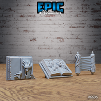 Three unpainted grey resin scatter terrain pieces from Epic Miniatures: a closed tome with a screaming beast embossed on the cover, an open grimoire on a reading stand with anguished faces carved into the pages, and a ceremonial scroll bound around ornate spindles — photographed on a wooden surface against a brick wall background.