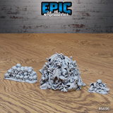 Three grey resin scatter terrain pieces from Epic Miniatures showing a large mound of tangled skeletal remains, a low pile of skulls, and a small bone scatter — all unpainted and viewed from a slightly elevated angle on a wooden surface