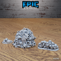 Alternate angle of the Epic Miniatures Skullbones Hill set showing the large bone mound from behind, the skull pile on the right, and the small bone scatter on the left — all grey unpainted resin on a wooden surface