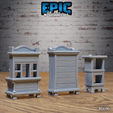 Rear view of the same three unpainted grey resin gothic wardrobe terrain pieces from Epic Miniatures, showing clean reverse sculpts of the tall wardrobe, wide chest-of-drawers cabinet, and slender pedestal table, demonstrating detail visible from all angles on the tabletop