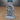 Unpainted grey resin dark gate terrain piece with skull-adorned stone arch, grasping tendrils coiling across a closed wooden door, six skulls set into the frame, and a raised stepped plinth base — sculpted by Epic Miniatures