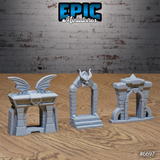 Three unpainted grey resin stone portal terrain pieces by Epic Miniatures — left: bat-wing archway with arcane sigil lintel; centre: pointed demon skull portal with horned skull keystone and fanged jaws; right: ruined stone archway with spiked capstone and crumbling secondary arch. Photographed on a wooden surface.