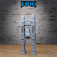 Unpainted grey resin bell tower terrain miniature with skeletal figures in hanging cage-lanterns and alcoves, featuring an ornate bell on a four-pillared stone arch structure with crenellated towers — front three-quarter view