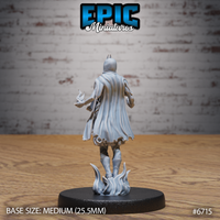 Rear view of the same unpainted grey resin Novice Lich miniature showing a billowing open coat with detailed hem and fabric folds, one hand raised with a small flame effect, small horned crest visible from behind, on a flame-tendril base