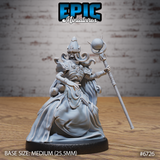 Unpainted grey resin miniature of a female lich in ceremonial robes, photographed from the front. She wears a tall ornate mitre helm over a skeletal face framed by flowing hair, holds an orb-topped staff in her right hand, and extends bony fingers of her left hand in a commanding gesture. Skull motifs decorate her chest armour. Mounted on a 25.5mm medium base. Epic Miniatures #6726.