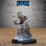 Front view of an unpainted grey resin Ghoul Gravecaller miniature by Epic Miniatures — a gaunt, hunched ghoulish figure in ragged robes clutching a humanoid skull in one clawed hand, adorned with strings of small bones across his belt and sash, mounted on a medium 25.5mm round base