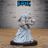 Rear view of the unpainted grey resin Ghoul Gravecaller miniature by Epic Miniatures — showing the full detail of bone fetishes and knotted finger-bone bundles across his back, flowing robes, and the skull held in his outstretched hand, mounted on a medium 25.5mm round base