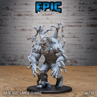 Front view of an unpainted grey resin Electric Frankenstein miniature on a 51mm base — a massive humanoid figure with chain-like tendrils erupting from his back and fists, twin coiled bolts in his shoulders, snarling leonine face, and one clawed foot pinning a smaller figure beneath him