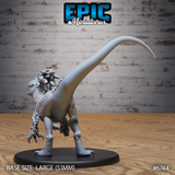 Unpainted grey resin raptor miniature by Epic Miniatures — rear three-quarter view showing the long arching tail, smooth flanks, feathered crest and frill at the back of the head, and powerful hindleg talons, on a large 51mm round black base