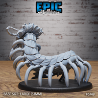 Unpainted grey resin Primal Centipede miniature by Epic Miniatures, shown from the rear-left angle on a 51mm oval black base, highlighting the overlapping chitinous plate segments across the creature's back, curved leg claws, and the sweeping crest of tendrils around its head