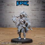 Front view of an unpainted grey resin Amazoness Champion miniature at 32mm scale, showing a female warrior in beast-pelt cloak and lion-skull headdress with one arm raised and wreathed in flame, mounted on a medium 25.5mm round black base