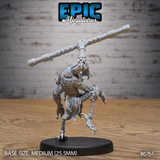 Rear view of an unpainted grey resin Insectoid Monk miniature by Epic Miniatures — showing broad textured chitin-armoured shoulders, a fanged mandible jaw visible over the creature's shoulder, articulated clawed limbs, and a long segmented staff raised aloft, on a medium 25.5mm round black base