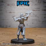 Rear view of the same unpainted grey resin barbarian miniature showing the battle-axe held across the back, detailed leather belt with studded trim, short blade tucked into the waistband, wrapped shin guards, and muscular back sculpt. Medium 25.5mm base.