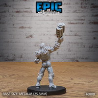 Long-haired brawler seen from behind, mechanical crusher arm thrust upward, spiked shoulder collar and reinforced jacket visible, standing on a round base. Sculpt by Epic Miniatures.