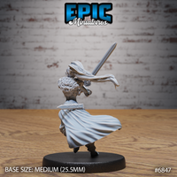 Elven female barbarian seen from behind, long hair and cape swept forward mid-turn, two-handed sword raised diagonally overhead, fur shoulder wrap and layered travelling clothes visible. Sculpt by Epic Miniatures.