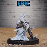 Rear view of seated female elf barbarian showing a dramatic flowing cloak billowing behind her, rope-wrapped armour on legs, and fur mantle across the shoulders. Sculpt by Epic Miniatures.
