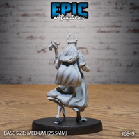 Antlered druid figure seen from behind, long hair spreading across shoulders, gnarled staff raised above head, wide flowing robes with sculpted movement at the hem, standing on a round base. Sculpt by Epic Miniatures.