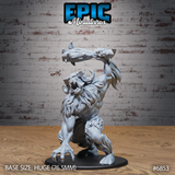 Huge abominable yeti rearing upright with a bone-and-horn club raised overhead in both hands, jaws wide open in a roar, dense shaggy fur covering chest and limbs, mounted on a large oval base. Sculpt by Epic Miniatures.
