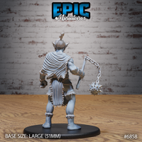 Firbolg barbarian seen from behind, revealing a draped fur cloak with ragged edges, top-knotted hair, and the spiked flail hanging at his side on a heavy chain, fur wraps at wrists and boots visible. Sculpt by Epic Miniatures.