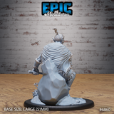 Firbolg barbarian seen from behind in a low crouch, showing a heavily textured fur-lined cape with deep fabric folds, rough topknot hair, and a spiked flail handle gripped at his side over a broken stone rubble base. Sculpt by Epic Miniatures.