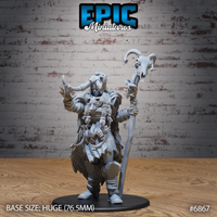 Frost Giantess miniature by Epic Miniatures — striding forward with one leg raised, right hand outstretched and fingers spread, gripping a tall bone staff crowned with a ram skull. Bald head with rising horns bound with rings, heavy fur cloak layered over torso armour with bone and leatherwork detailing. Mounted on a 76.5mm round base.
